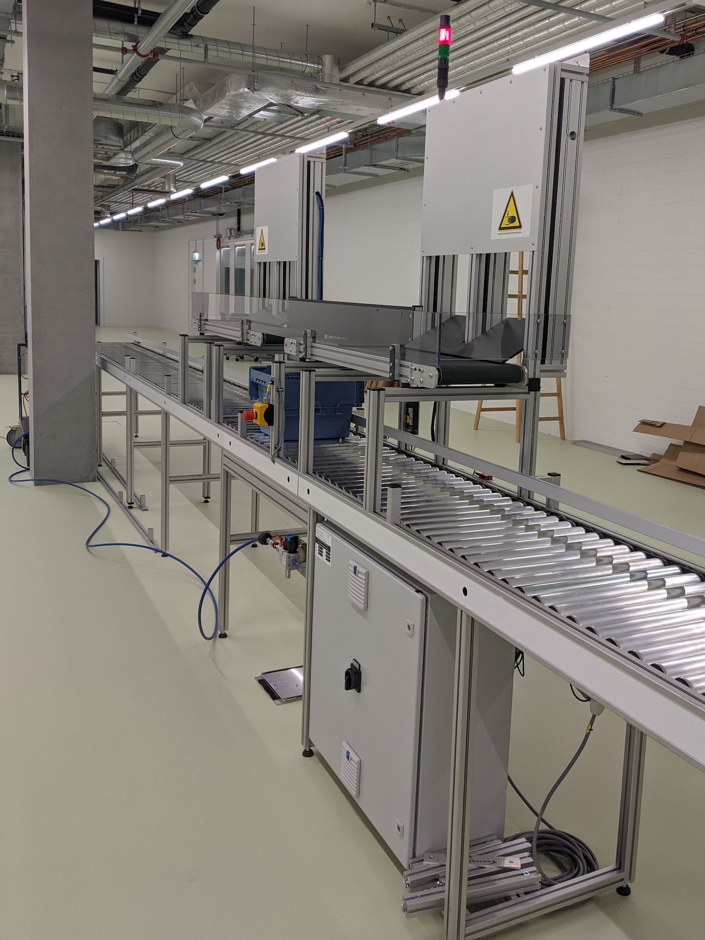 Conveyors for containers filled by a dispensing robot